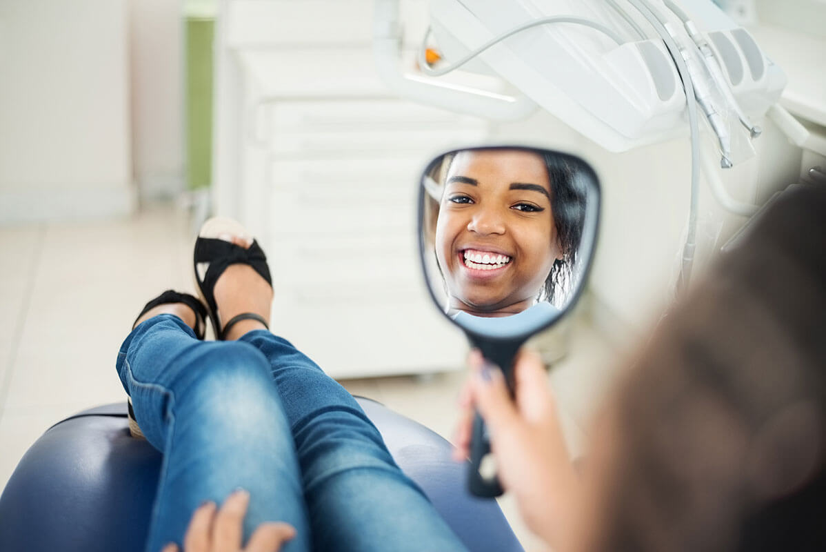 happy-female-patient-looking-in-mirror